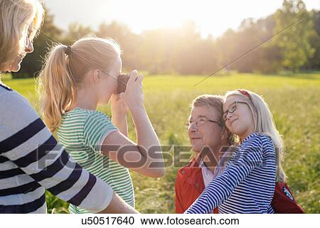 Girl photographing grandfather and sister View Large Photo Image Stock Image - Girl photographing grandfather and sister. Fotosearch