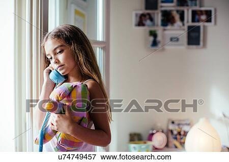 Stock Photo - Girl using landline phone. Fotosearch