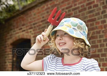 Girl with holding garden trowel View Large Photo Image Stock Image - Girl with holding garden trowel. Fotosearch