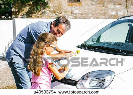 Grandfather and granddaughter washing car View Large Photo Image Picture - Grandfather and granddaughter washing car. Fotosearch