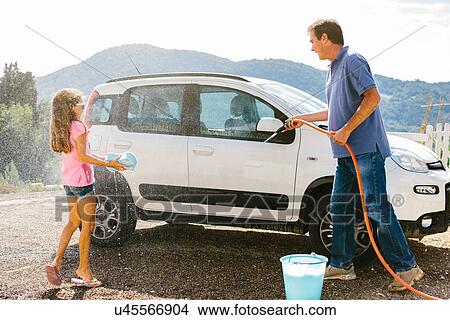 Picture - Grandfather and granddaughter washing car. Fotosearch