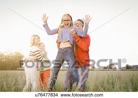 Grandfather lifting granddaughter in field View Large Photo Image Picture - Grandfather lifting granddaughter in field. Fotosearch
