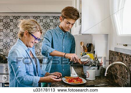 Grandmother and grandson preparing food View Large Photo Image Stock Image - Grandmother and grandson preparing food. Fotosearch