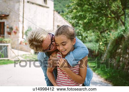 Grandmother kissing granddaughter on cheek View Large Photo Image Stock Image - Grandmother kissing granddaughter on cheek. Fotosearch