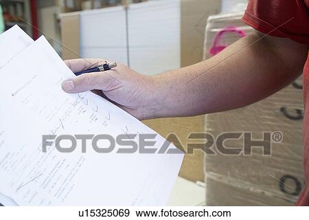 Stock Photo - Hand of male warehouse worker collecting order for hardware store. Fotosearch