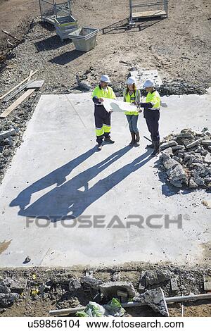 High angle view of architects and site manager meeting on construction site View Large Photo Image Picture - High angle view of architects and site manager meeting on construction site. Fotosearch