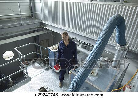 High angle view of factory worker carrying plastic container View Large Photo Image Stock Photograph - High angle view of factory worker carrying plastic container. Fotosearch