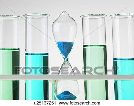 Stock Image - Hour glass sitting in a test tube rack to illustrate time factor to bring research ideas to market. Fotosearch