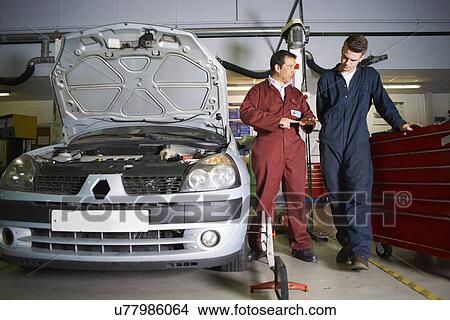 Lecturer explaining to male student in college garage View Large Photo Image Picture - Lecturer explaining to male student in college garage. Fotosearch