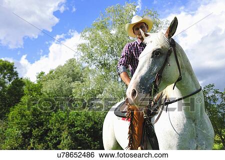 Low angle portrait of young man in cowboy gear on horse View Large Photo Image Stock Photograph - Low angle portrait of young man in cowboy gear on horse. Fotosearch