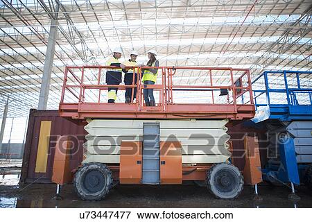 Low angle view of site managers and architect on viewing platform on construction site View Large Photo Image Stock Photo - Low angle view of site managers and architect on viewing platform on construction site. Fotosearch