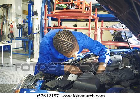 Male college student looking at car engine in garage workshop View Large Photo Image Stock Photo - Male college student looking at car engine in garage workshop. Fotosearch