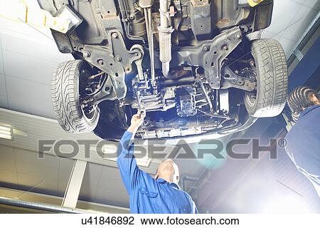 Male college student looking up at car in garage workshop View Large Photo Image Stock Image - Male college student looking up at car in garage workshop. Fotosearch