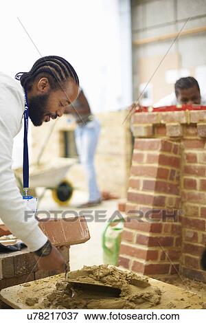 Male college student using cement trowel in bricklaying workshop View Large Photo Image Stock Photo - Male college student using cement trowel in bricklaying workshop. Fotosearch