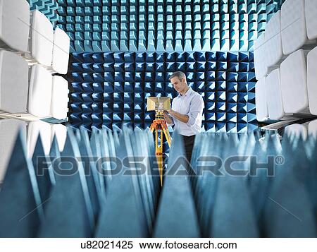Stock Photography - Male scientist preparing to measure electromagnetic waves in anechoic chamber. Fotosearch
