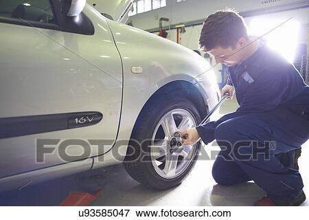 Male student mechanic tightening car wheel in college garage View Large Photo Image Stock Photo - Male student mechanic tightening car wheel in college garage. Fotosearch