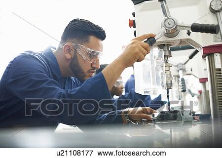 Male student using drilling machine in college workshop View Large Photo Image Stock Photo - Male student using drilling machine in college workshop. Fotosearch