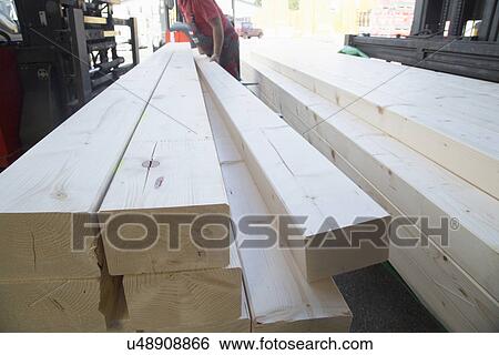Male warehouse worker stacking wooden planks for hardware store View Large Photo Image Stock Photograph - Male warehouse worker stacking wooden planks for hardware store. Fotosearch