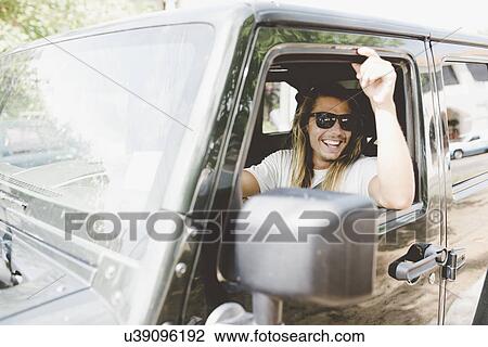 Stock Image - Man behind wheels looking out of van. Fotosearch