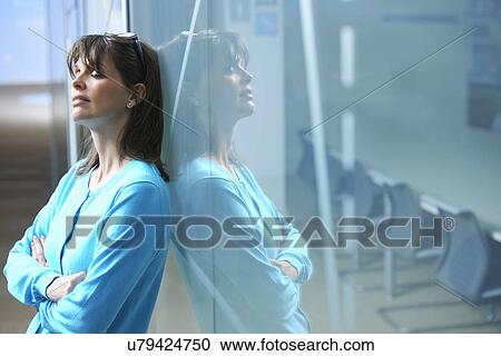 Mature businesswoman leaning against glass wall in office with eyes closed View Large Photo Image Stock Image - Mature businesswoman leaning against glass wall in office with eyes closed. Fotosearch