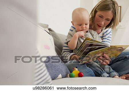 Mature mother and baby daughter on sitting room sofa reading storybook View Large Photo Image Stock Image - Mature mother and baby daughter on sitting room sofa reading storybook. Fotosearch