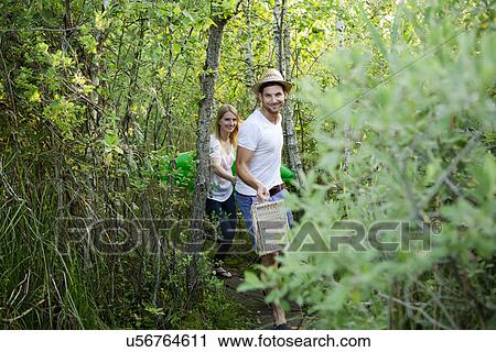 Mid adult couple walking through marshland with picnic basket View Large Photo Image Stock Image - Mid adult couple walking through marshland with picnic basket. Fotosearch