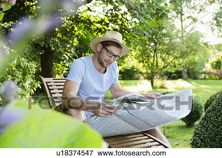 Mid adult man reading newspaper in garden View Large Photo Image Stock Photo - Mid adult man reading newspaper in garden. Fotosearch