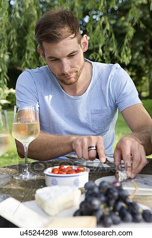 Mid adult man sitting at picnic table in garden View Large Photo Image Stock Photo - Mid adult man sitting at picnic table in garden. Fotosearch