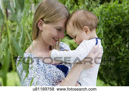 Mother and baby daughter face to face in garden View Large Photo Image Stock Photo - Mother and baby daughter face to face in garden. Fotosearch