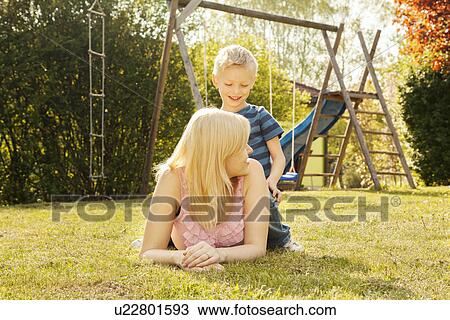 Mother and son in garden, swings in background View Large Photo Image Stock Image - Mother and son in garden, swings in background. Fotosearch