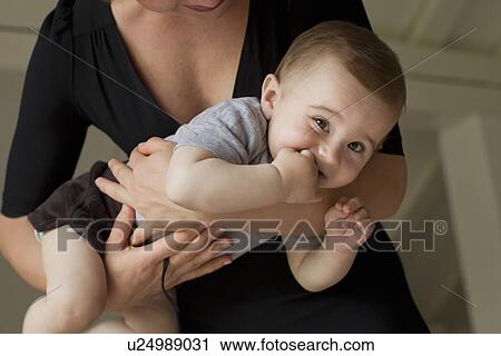 Stock Image - Mother holding baby boy. Fotosearch