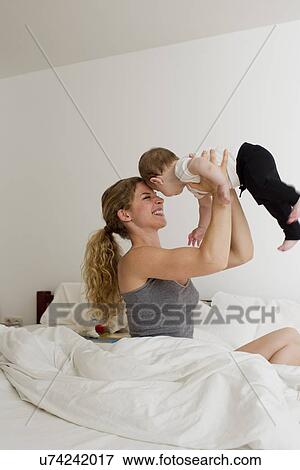 Mother holding baby boy up in mid air View Large Photo Image Stock Photo - Mother holding baby boy up in mid air. Fotosearch