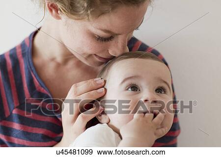 Mother nuzzling baby boy on head View Large Photo Image Stock Photo - Mother nuzzling baby boy on head. Fotosearch