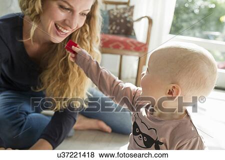 Stock Photo - Mother playing with baby boy. Fotosearch