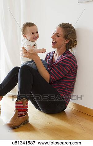 Stock Photo - Mother playing with baby boy. Fotosearch
