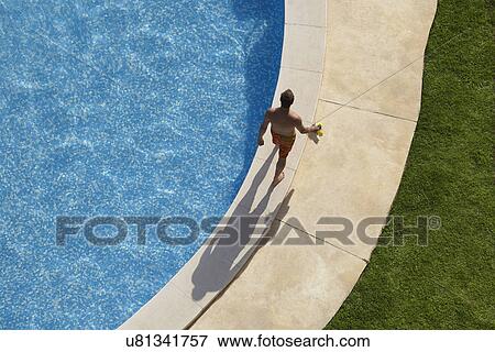 Overhead view of man walking around swimming pool View Large Photo Image Stock Photo - Overhead view of man walking around swimming pool. Fotosearch