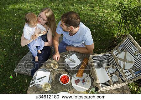 Overhead view of mid adult couple and baby daughter sitting at picnic table in garden View Large Photo Image Stock Image - Overhead view of mid adult couple and baby daughter sitting at picnic table in garden. Fotosearch