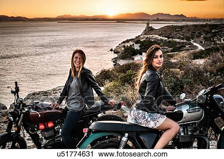 Portrat Von Zwei Motorradfahrerin Freunde Auf Kustenlandschaften An Sonnenuntergang Cagliari Sardinien Italien Stock Bild U Fotosearch