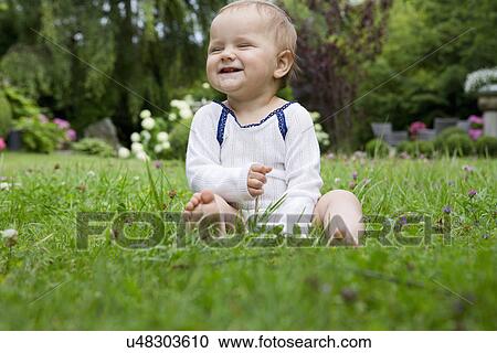 Portrait of baby girl sitting on lawn laughing View Large Photo Image Stock Image - Portrait of baby girl sitting on lawn laughing. Fotosearch