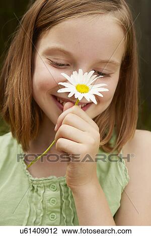 Portrait of girl in garden holding up daisy View Large Photo Image Stock Image - Portrait of girl in garden holding up daisy. Fotosearch