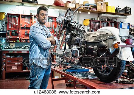 Portrait of male mechanic with arms crossed in motorcycle workshop View Large Photo Image Stock Photograph - Portrait of male mechanic with arms crossed in motorcycle workshop. Fotosearch