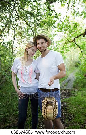 Portrait of mid adult couple at lakeside carrying lantern View Large Photo Image Stock Photography - Portrait of mid adult couple at lakeside carrying lantern. Fotosearch