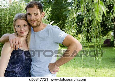Stock Image - Portrait of mid adult couple in garden. Fotosearch