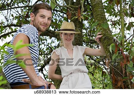 Portrait of mid adult couple next to garden tree View Large Photo Image Stock Image - Portrait of mid adult couple next to garden tree. Fotosearch
