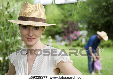 Portrait of mid adult woman in front of family in garden View Large Photo Image Stock Photo - Portrait of mid adult woman in front of family in garden. Fotosearch