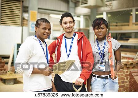 Stock Photograph - Portrait of three college students in bricklaying workshop. Fotosearch