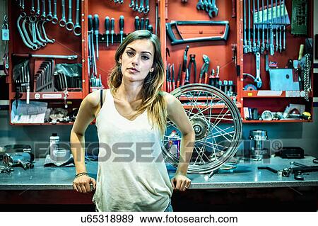 Portrait of young female mechanic in motorcycle workshop View Large Photo Image Stock Photo - Portrait of young female mechanic in motorcycle workshop. Fotosearch