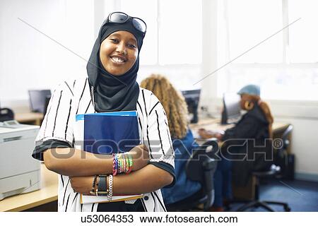 Portrait of young female student with file in college classroom View Large Photo Image Stock Image - Portrait of young female student with file in college classroom. Fotosearch