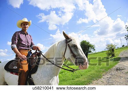 Portrait of young man in cowboy gear on horse on rural road View Large Photo Image Stock Image - Portrait of young man in cowboy gear on horse on rural road. Fotosearch