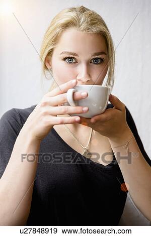 Portrait of young woman drinking coffee View Large Photo Image Stock Photo - Portrait of young woman drinking coffee. Fotosearch